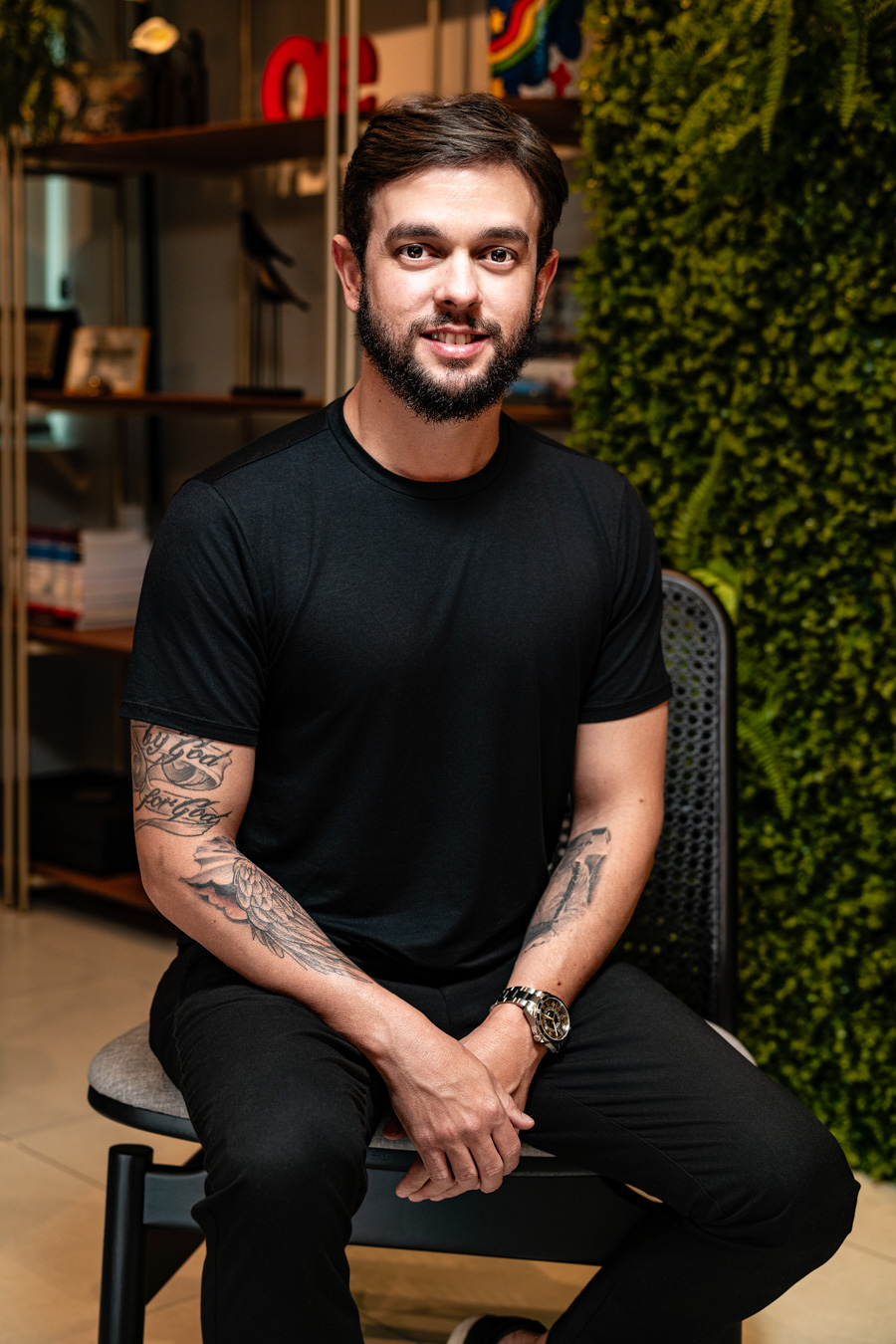 Carlos Diego Cavalcanti Pereira sentado, de camiseta preta, em ambiente de escritório